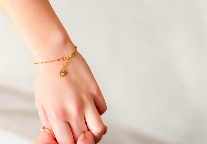 Gold bow chain bracelet with charm