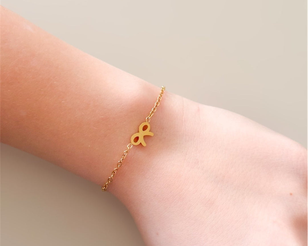 Gold bow chain bracelet with charm