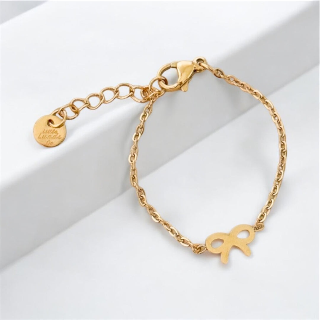 Gold bow chain bracelet with charm