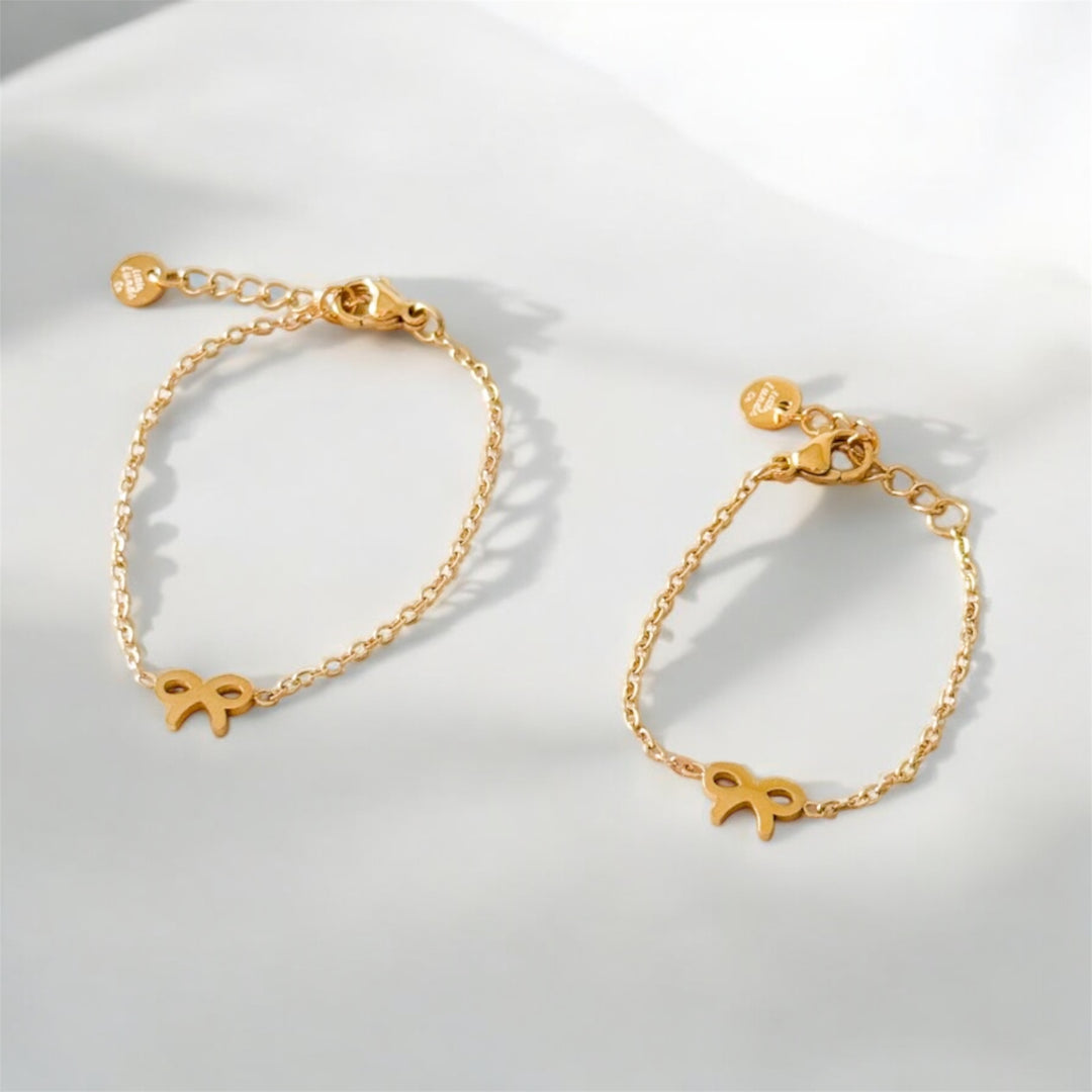 Gold bow chain bracelet with charm