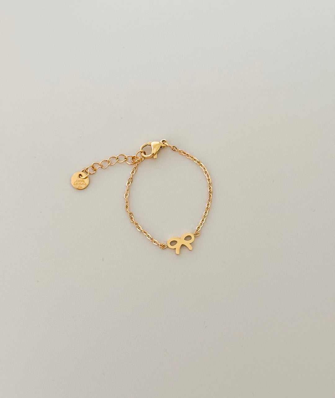 Gold bow chain bracelet with charm