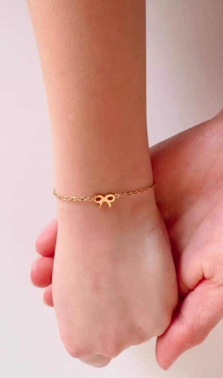 Gold bow chain bracelet with charm